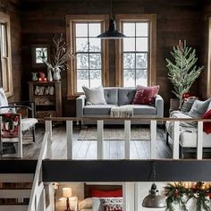 a living room filled with furniture and christmas decorations on top of wooden floored floors