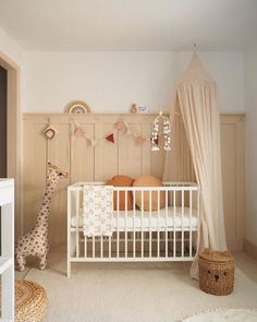 a baby's room with a crib, bed and stuffed giraffe