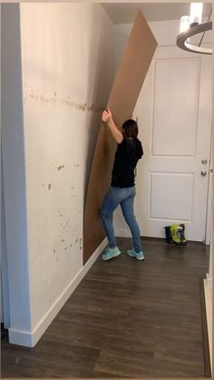 a woman is holding up a cardboard wall