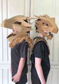 two people wearing paper masks made to look like dragon heads