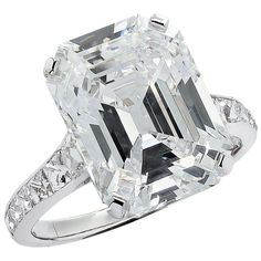 an emerald - cut diamond ring with diamonds surrounding it, set in 18k white gold