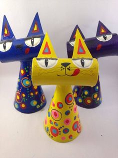 three colorful cat figurines sitting next to each other