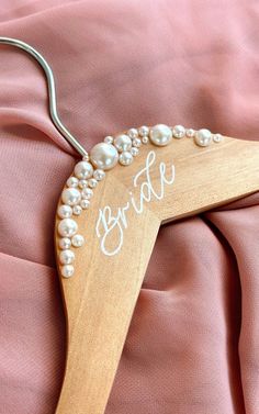 a bride's hanger with pearls on it and the word bride written on it