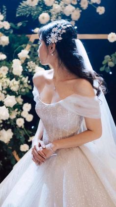 a woman in a wedding dress standing next to flowers