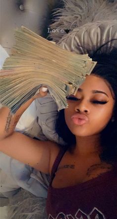 a woman laying on top of a bed covered in lots of money