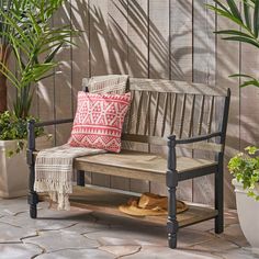 a wooden bench sitting next to a potted plant