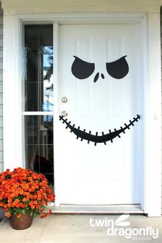 a front door decorated for halloween with pumpkins