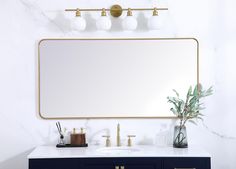 a bathroom vanity with a large mirror above it and two lights on the wall next to it