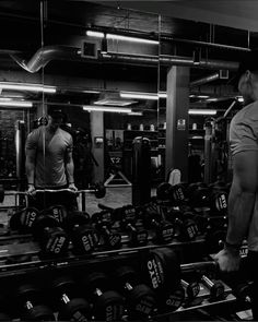 two men working out in the gym with dumbs and weight plates on each side