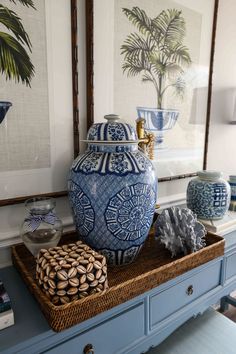 a blue and white vase sitting on top of a wooden table next to other items