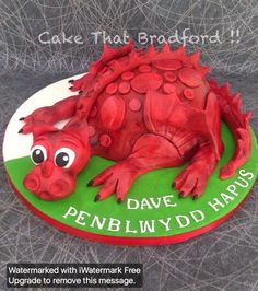 there is a cake shaped like a red dragon on the plate that says, cake that's attached to it