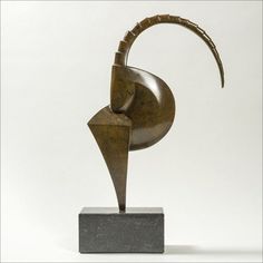 a bronze sculpture on a black base with a white background in the backround