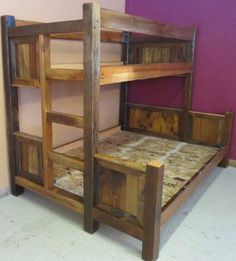 a wooden bunk bed sitting in a room next to a purple wall and white floor