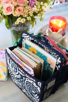 a vase filled with lots of flowers next to an open book case on top of a table