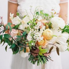 a woman holding a bouquet of flowers in her hands