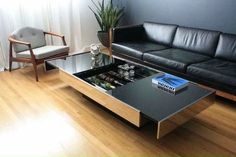 a black leather couch sitting next to a table with a book on top of it