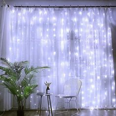 a chair and table in front of a curtain with lights