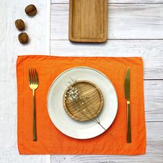 a white plate topped with food on top of a wooden cutting board next to silverware