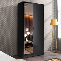 a bedroom with a large black cabinet next to a lamp and a bed in it