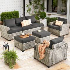 an outdoor living room with grey wicker furniture