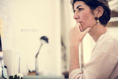 a woman sitting in front of a computer desk with her chin resting on her hand