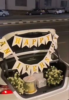 an open trunk filled with flowers on the back of a car