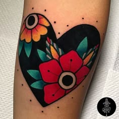 a heart shaped tattoo with flowers on it