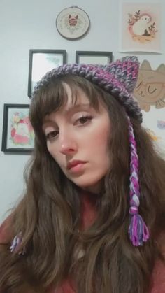 a woman with long hair wearing a knitted hat and looking off to the side