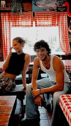 two people sitting at a table in front of a red and white checkered table cloth