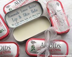 four tins of lip and skin balm on a white sheet with a bow