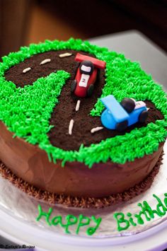 a birthday cake that is shaped like a tractor and dirt track with the number six on it