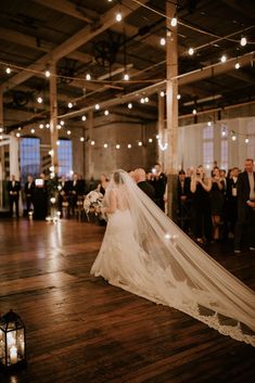 a bride and groom kissing in front of their wedding guests at the end of an aisle