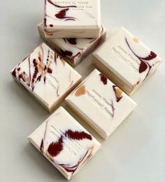 four pieces of chocolate with white and red swirls on them, sitting next to each other