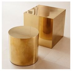 two gold colored tables sitting next to each other on a white floor with one table in the middle