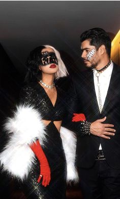 a man and woman dressed up in black with red gloves, white feathers and makeup