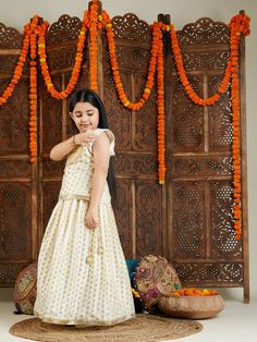 VASTRAMAY Girls' Cream And Gold Jacquard Lehenga Dress your little one in style with this beautiful cream and gold jacquard lehenga set. Features a handcrafted choli with yoke detailing and a lehenga with an elasticated waistband for a comfortable fit. Perfect for festive occasions and special events. Key Features Handcrafted choli and lehenga set Cream and gold jacquard fabric Sleeveless choli with yoke detailing and round neck Tie-up back detailing for adjustability Lehenga with elasticated wa Cream Bollywood Set With Self Design, Bollywood Style Cream Self-design Set, Bollywood Cream Self-design Set, Gold Brocade Choli For Eid, Festive Cream Lehenga, Festive Cream Self Design Sets, Cream Art Silk Set For Diwali, Festive Gold Brocade Set, Cream Sets With Pallu For Navratri