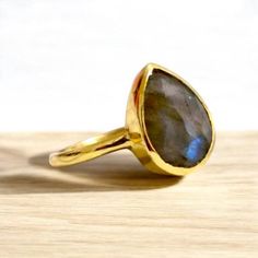 Minimalist Labradorite Promise Ring - 18k Gold Jewelry by KOHI Embrace the magic of subtle elegance with our Minimalist Labradorite Promise Ring. This exquisite piece features a radiant labradorite stone, renowned for its mesmerizing rainbow flashes and iridescent glow. Set in a luxurious 18k gold band, this ring is a harmonious blend of sophistication and modern simplicity. Key Features:     Labradorite Gemstone: Known for its captivating play of color and ethereal shine, each stone is carefull Yellow Gold Labradorite Ring For Gift, Spiritual Gold Labradorite Rings, Handmade Yellow Gold Teardrop Ring, Drop Ring, Teardrop Ring, Sterling Silver Jewelry Handmade, 18k Gold Jewelry, Labradorite Ring, Labradorite Stone