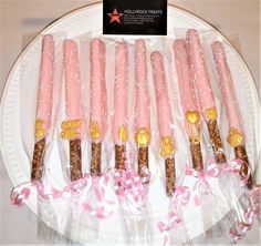 pink and gold candy sticks are on a plate