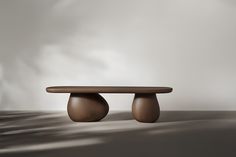 a wooden table sitting on top of a floor next to a white wall with clouds in the background