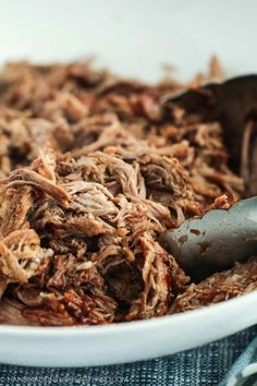 shredded meat in a white bowl with a spoon