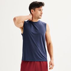 a man wearing red shorts and a blue tank top with his hand on his shoulder