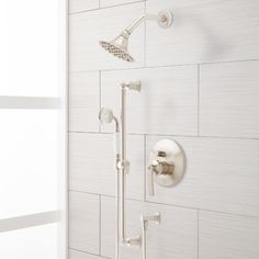 the shower head and hand shower faucet are shown in this white tiled bathroom