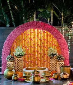 a table topped with vases filled with flowers and gold containers on top of it