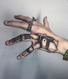 a person's hand with a tattoo on it and a camera in the palm