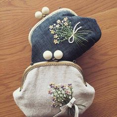 two purses sitting on top of a wooden table next to each other with beaded decorations