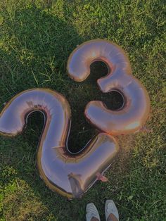 an inflatable balloon shaped like the letter s is laying on the ground next to a pair of shoes