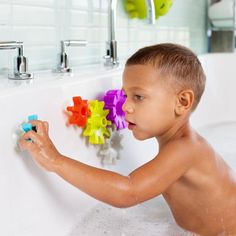 a young boy is playing with toys in the bathtub