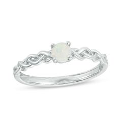 a white opalite ring with an intricate design on the front and side, set in