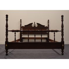 an antique wooden bed frame with posts and headboard