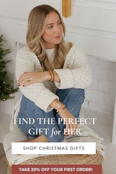 a woman sitting on the floor in front of a christmas tree with her arms crossed